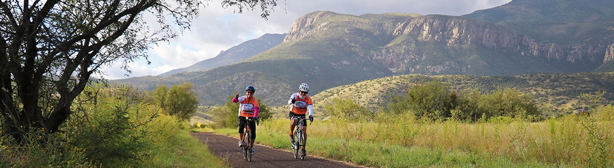 Two cyclist with mountains in the background