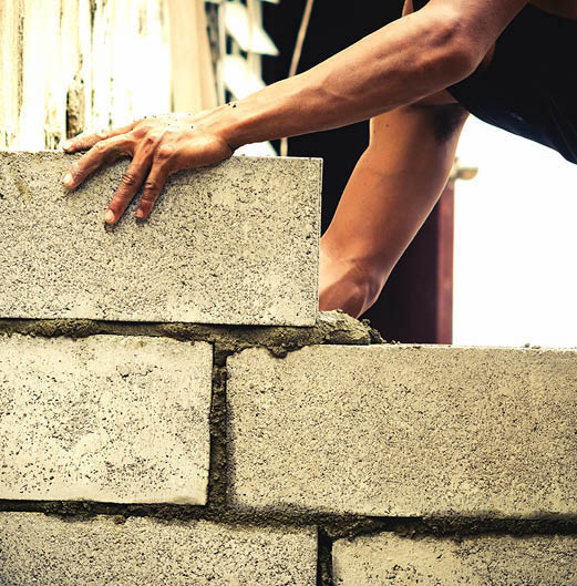 A mason laying cinder block