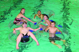 A group of children in innertubes in swimming pool