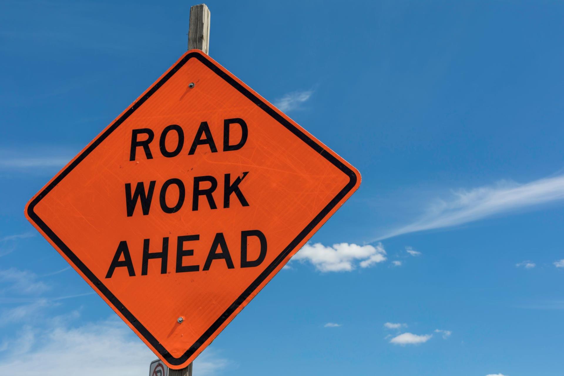 Road Work Ahead sign sky clouds