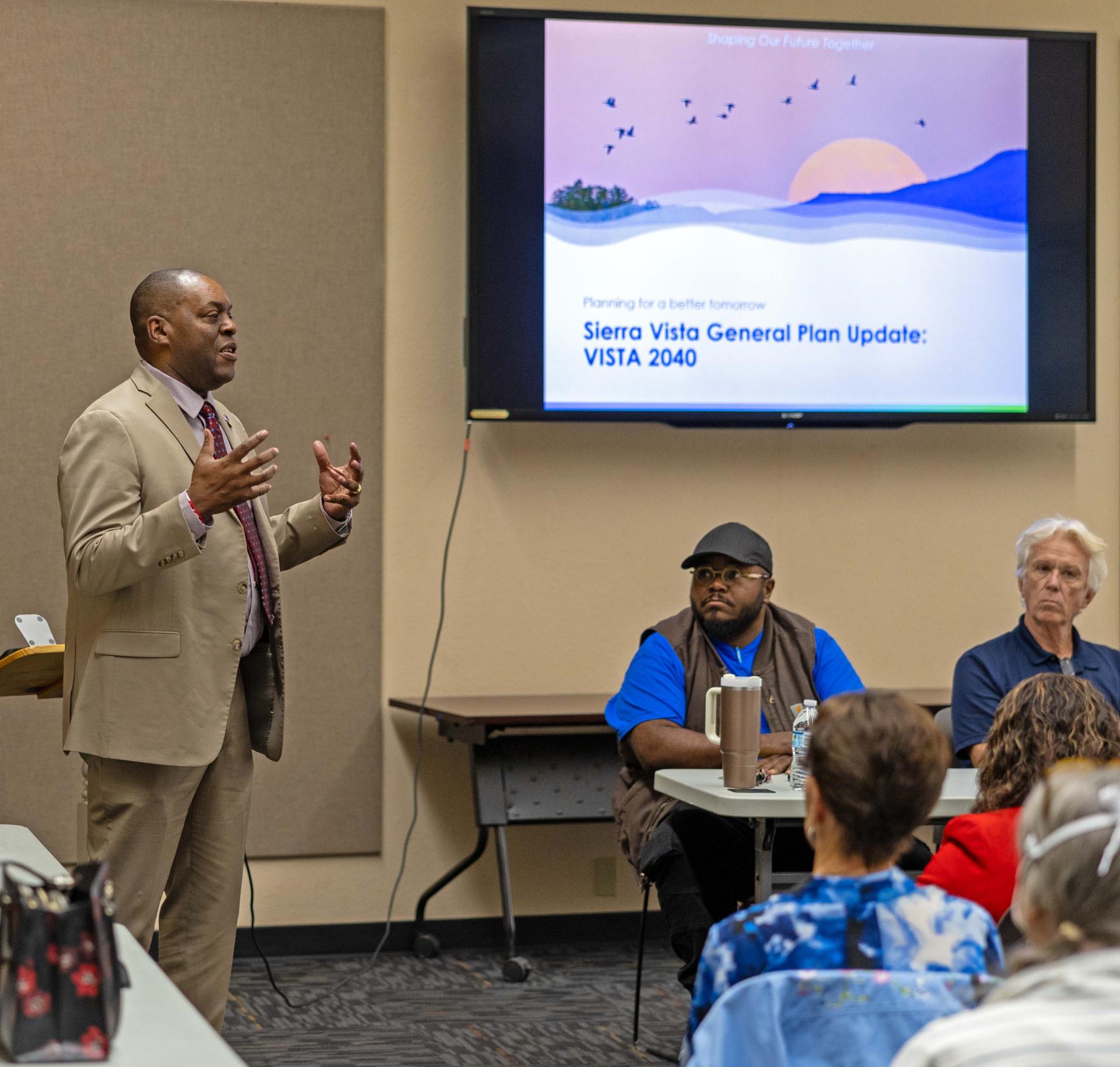 A man addresses room of people