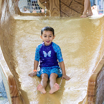 A little boy on a water slide