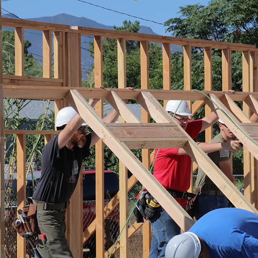 Construction workers installing the frame of a wall