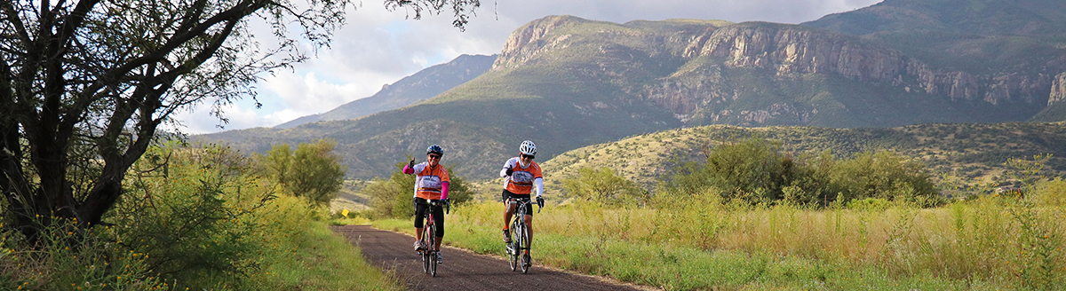 Two cyclist with the mountains in the background