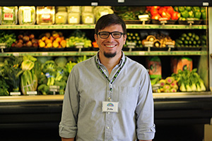 Man standing in front of produce at a grocery store