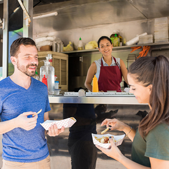 Man and woman eating at a food truck