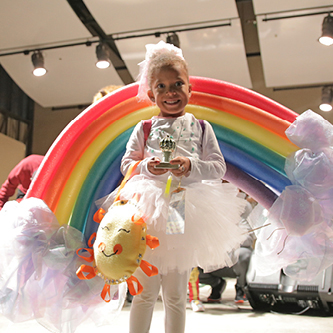 Little girl standing in front of a rainbow